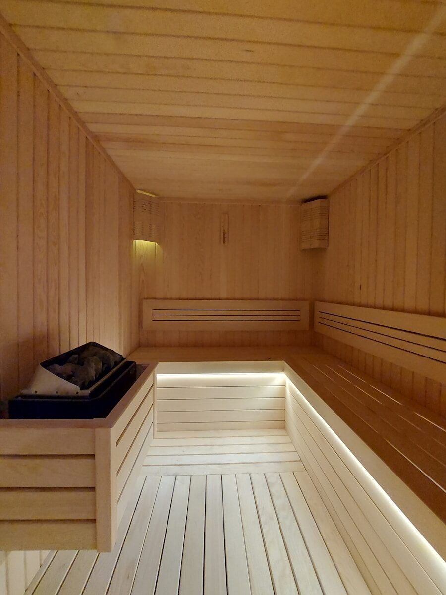 a wooden room with a bench and a light